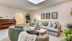 A living room with a piano, a sofa, a coffee table, and a large window. - 4 Mi to Capitol: Spacious Springfield Home w/ Deck (Springfield)