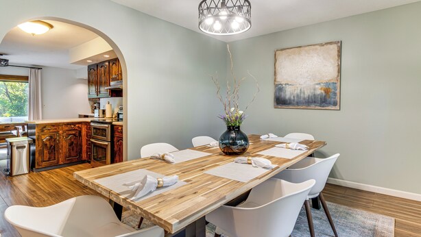 A dining area with a wooden table, white chairs, and a vase with branches. - 4 Mi to Capitol: Spacious Springfield Home w/ Deck (Springfield)