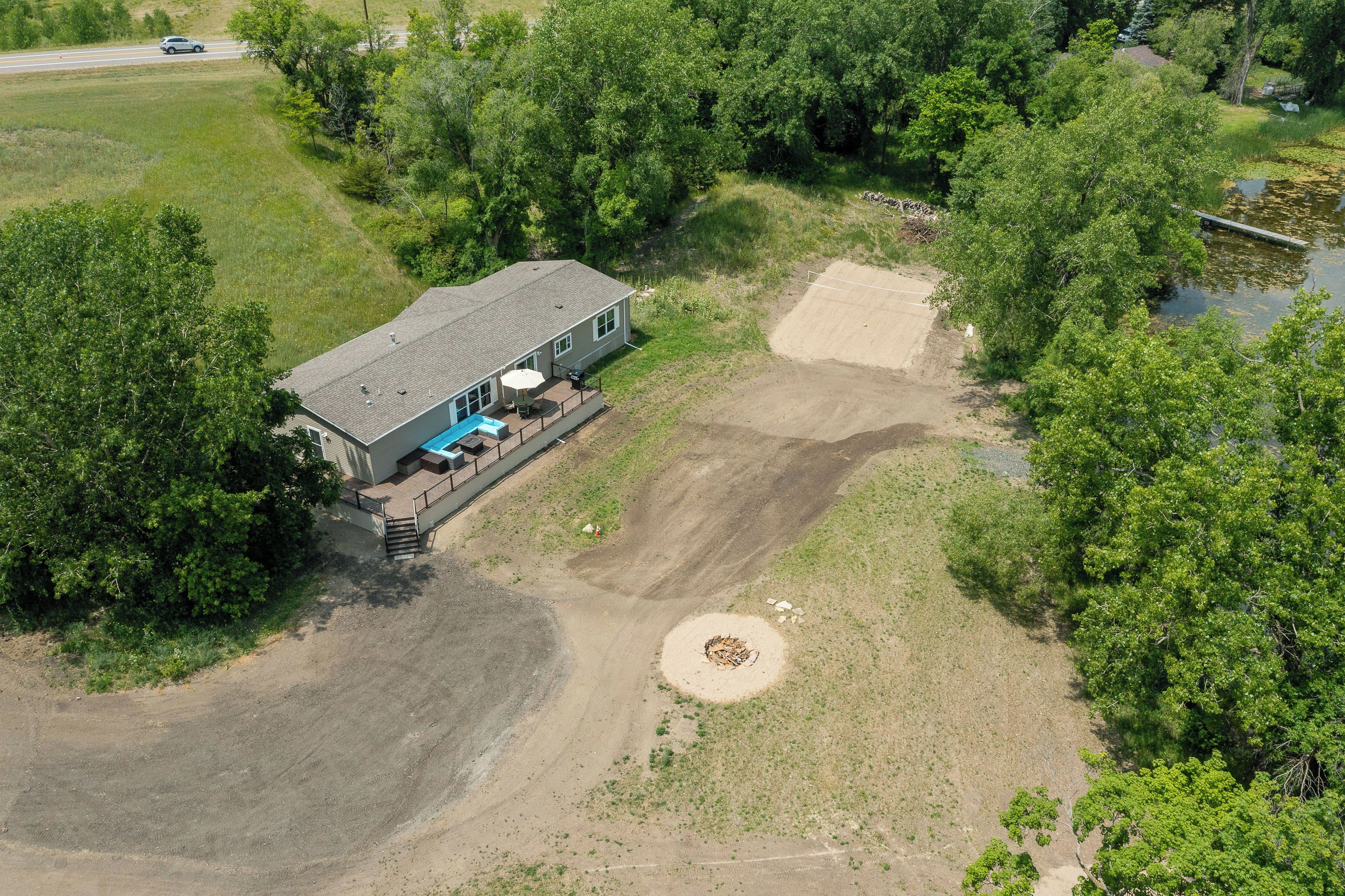 An aerial view of a house with a patio, a swimming pool, and a large yard.