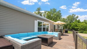 A covered outdoor deck with a sectional sofa and a grill area. - Fish & Relax Fireside: Mink Lake Retreat! (Buffalo)