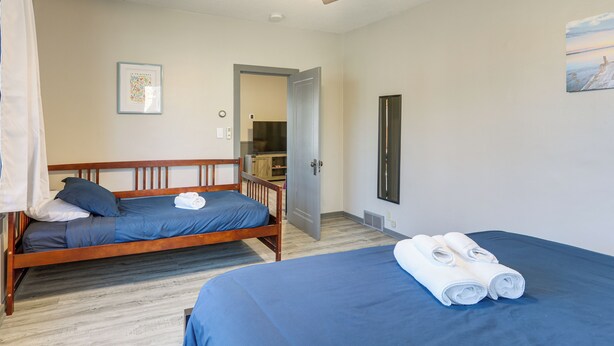 A bedroom with two beds, a ceiling fan, and a painting on the wall. - Steps to Shore! Pet-friendly Lake Waconia Getaway (Waconia)