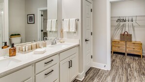 A bathroom with a white vanity, a large mirror, and a wooden floor. - Family Getaway in Calabash w/ Pool; 9 Mi to Beach (Calabash)
