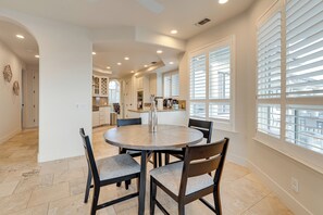 A dining area with a round table, four chairs, and a kitchen in the background. - Luxury Pilot Hill Estate in a Vineyard Community (Pilot Hill)