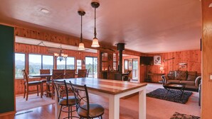 A wooden interior with a dining area, kitchen, and living space. - Close to Pike Natl Forest! Lake-view Family Cabin (Divide)
