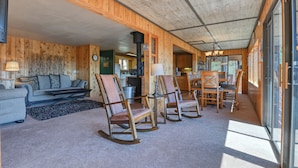A cozy cabin interior with a living area featuring a sofa, chairs, and a dining table. - Close to Pike Natl Forest! Lake-view Family Cabin (Divide)