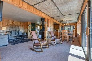 Een gezellig chaletinterieur met een zithoek, inclusief een bank, stoelen en een eettafel.