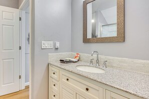 A bathroom with a white sink, a mirror with a textured frame, and a towel on the counter. - Fish, Hike & Explore: Mtn-view Lake George Studio (Florissant)