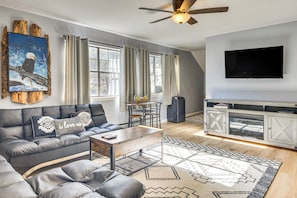 A modern living room with a sectional sofa, a coffee table, a TV, and a fireplace. - Fish, Hike & Explore: Mtn-view Lake George Studio (Florissant)