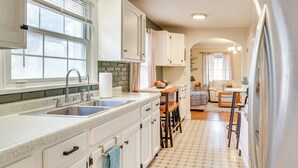 A kitchen with white cabinets, a double sink, and a wooden island. - Quiet Home Base in the Heart of Boardman! (Boardman)