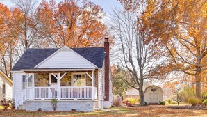 A small house with a porch, a chimney, and a shed in a yard with fallen leaves. - Quiet Home Base in the Heart of Boardman! (Boardman)