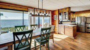 Eine moderne Küche mit einer großen Kochinsel, Holzböden und Meerblick.
