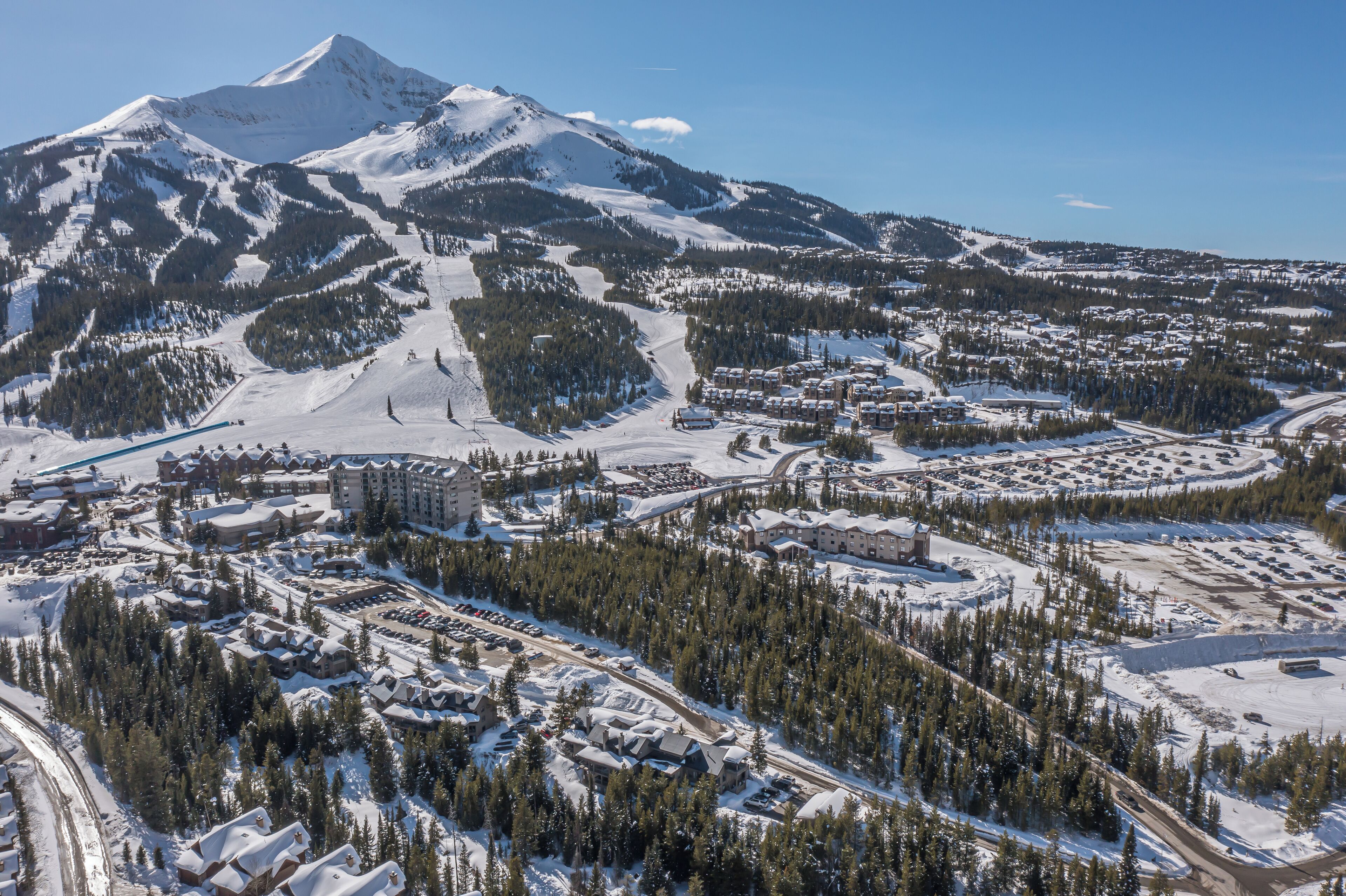 A snow-covered mountain town with a ski resort, buildings, and roads.