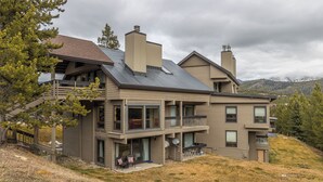 A two-story house with a balcony, large windows, and a satellite dish. - Beautiful Mountain Views, walking distance to Big Sky Resort! (Big Sky)