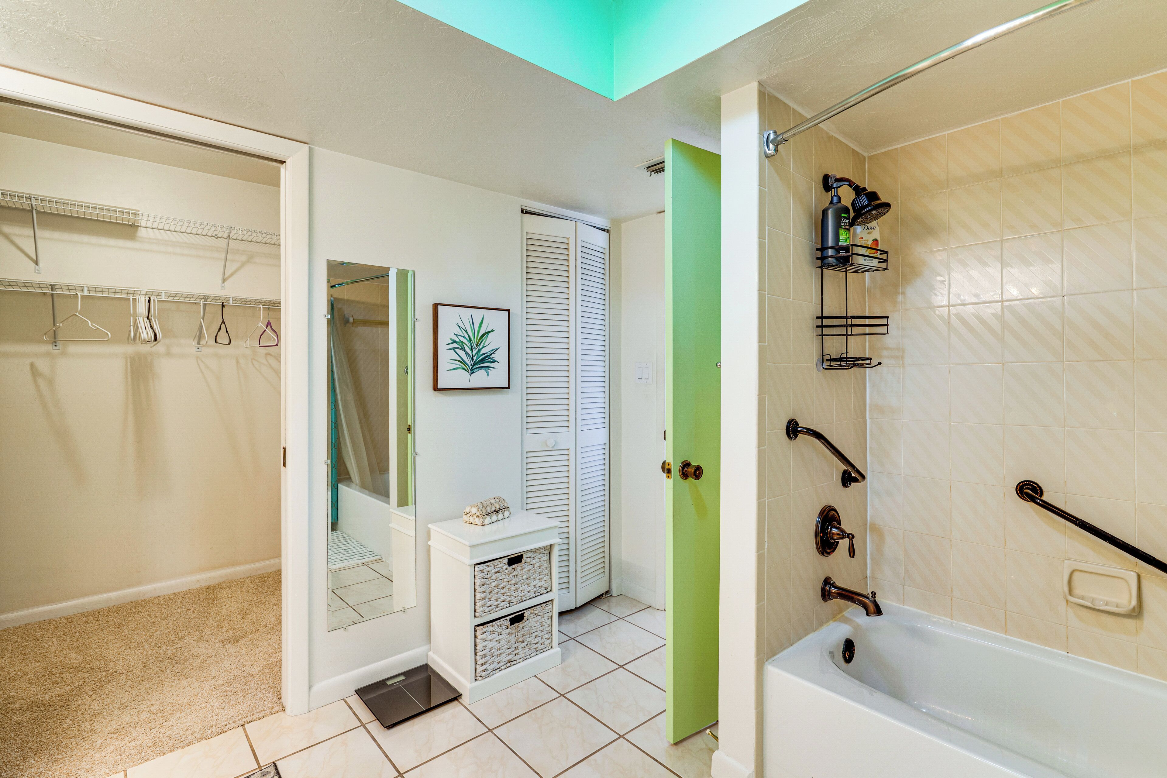 A bathroom with a bathtub, a shower, a toilet, and a sink. There is a mirror above the sink and a towel rack on the wall.