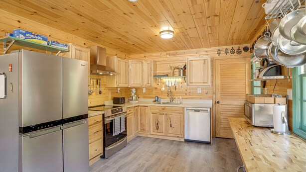 A modern kitchen with wooden cabinets, stainless steel appliances, and a wooden ceiling. - Hike On-site! 16-acre Escape Near Shenandoah NP (Stanley)
