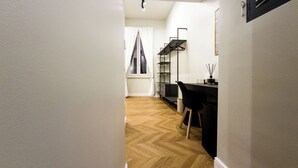 A hallway leading to a room with a desk, chair, and a window with curtains. - Domus Innovatis Rooms & Home (Rome)