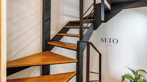 Una escalera moderna con escalones de madera y barandillas de metal negro.