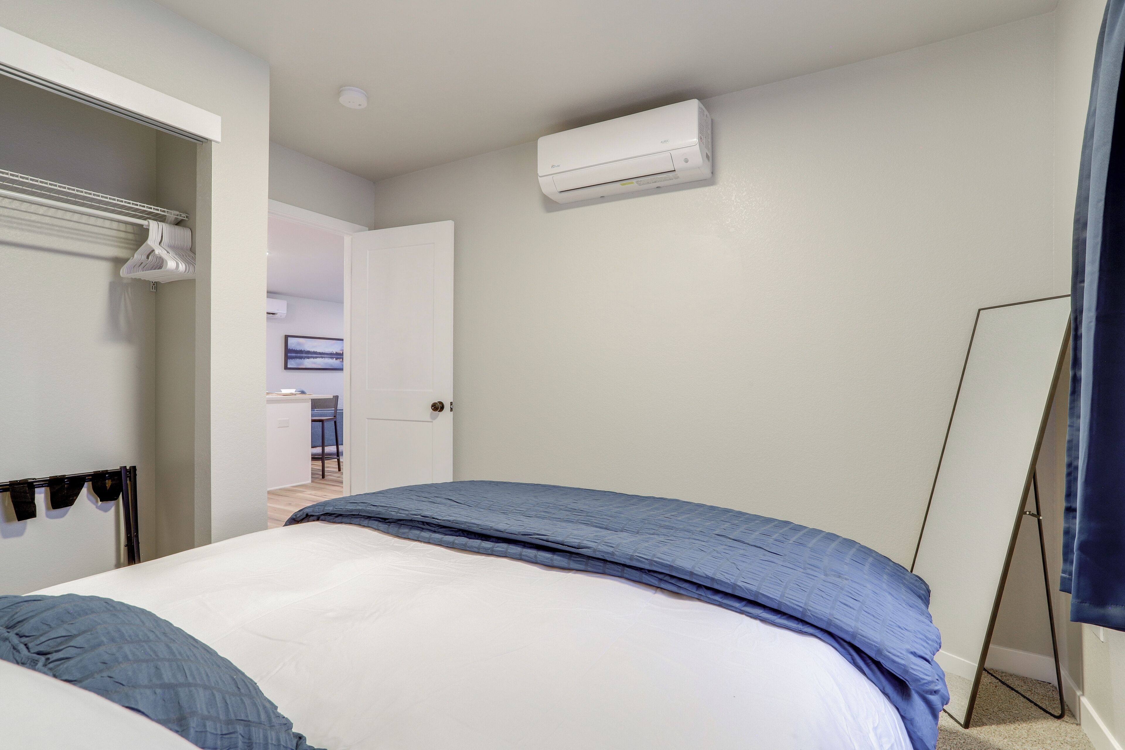 Une chambre à coucher comprenant un lit, une armoire et un appareil de climatisation.