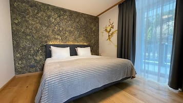 Un dormitorio con una cama grande, una pared con textura y una ventana con cortinas.