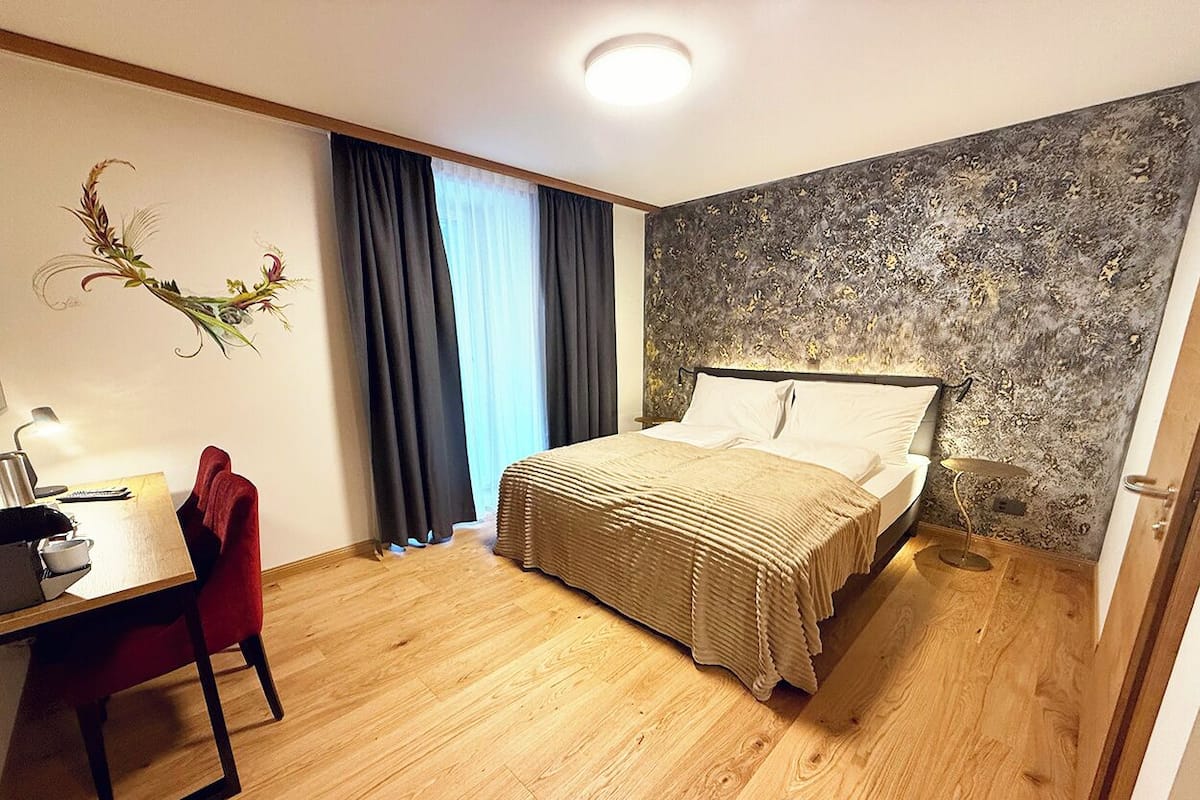 Een slaapkamer met een bed, een bureau en een stoel.