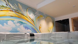 A hot tub with a mural of a sky and clouds. - Gemmi Hotel & Spa (Kandersteg)