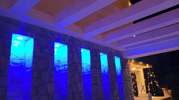 A modern building with stone columns and blue lighting. - Swapno Chhobi (Bolpur)