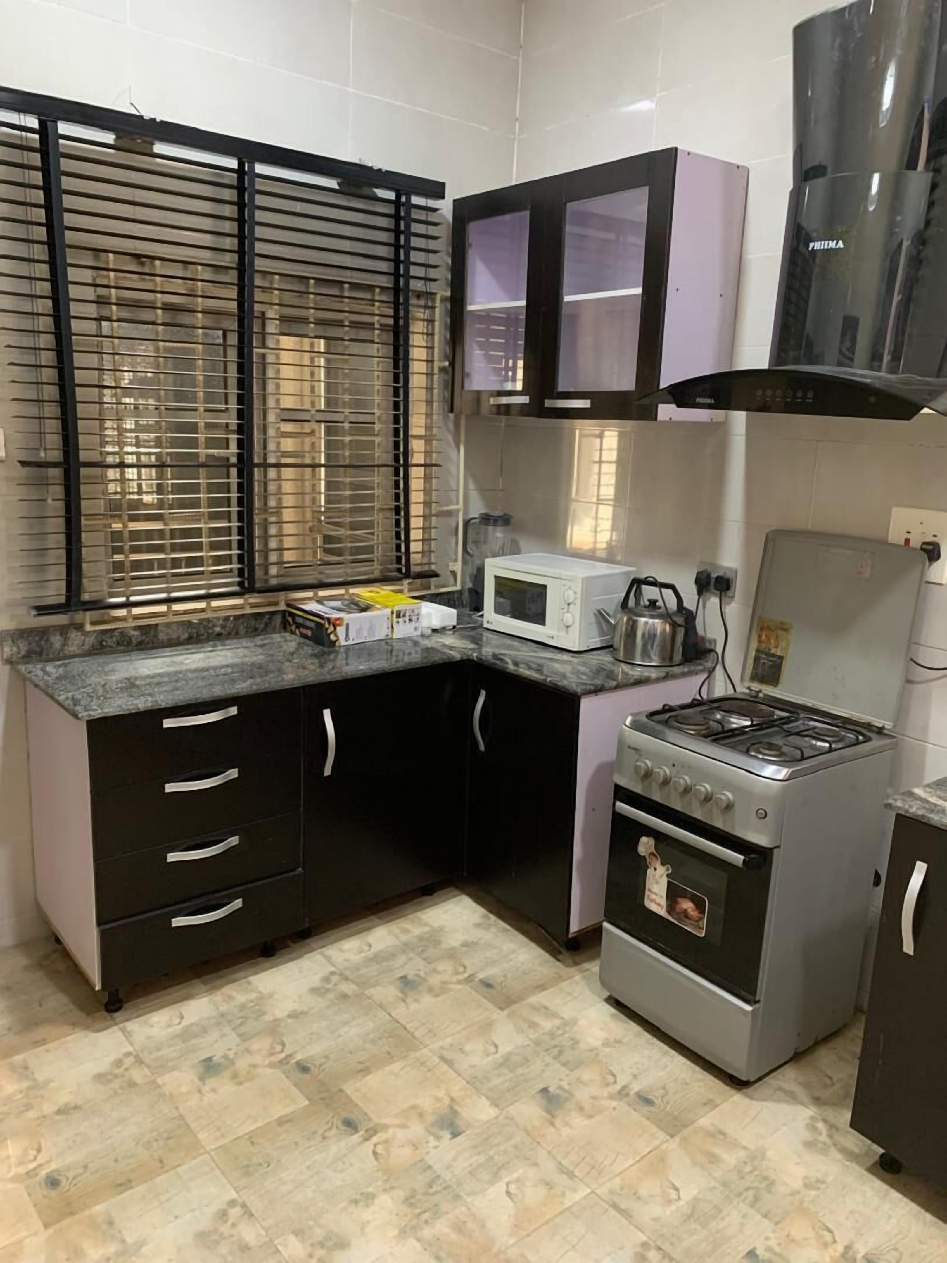 Habitación de lujo | Cocina privada | Refrigerador con congelador, parrilla de estufa y utensilios de cocina 