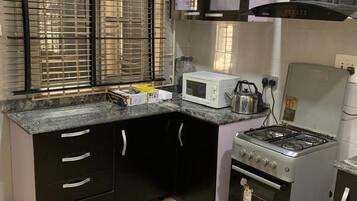 Habitación de lujo | Cocina privada | Refrigerador con congelador, parrilla de estufa y utensilios de cocina