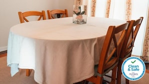 A round dining table with a white tablecloth, surrounded by wooden chairs. - Apartment in the city center with spectacular views and easy access. (Ponta Delgada)