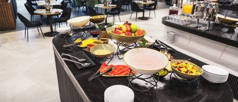 A buffet setup with various food items and utensils.