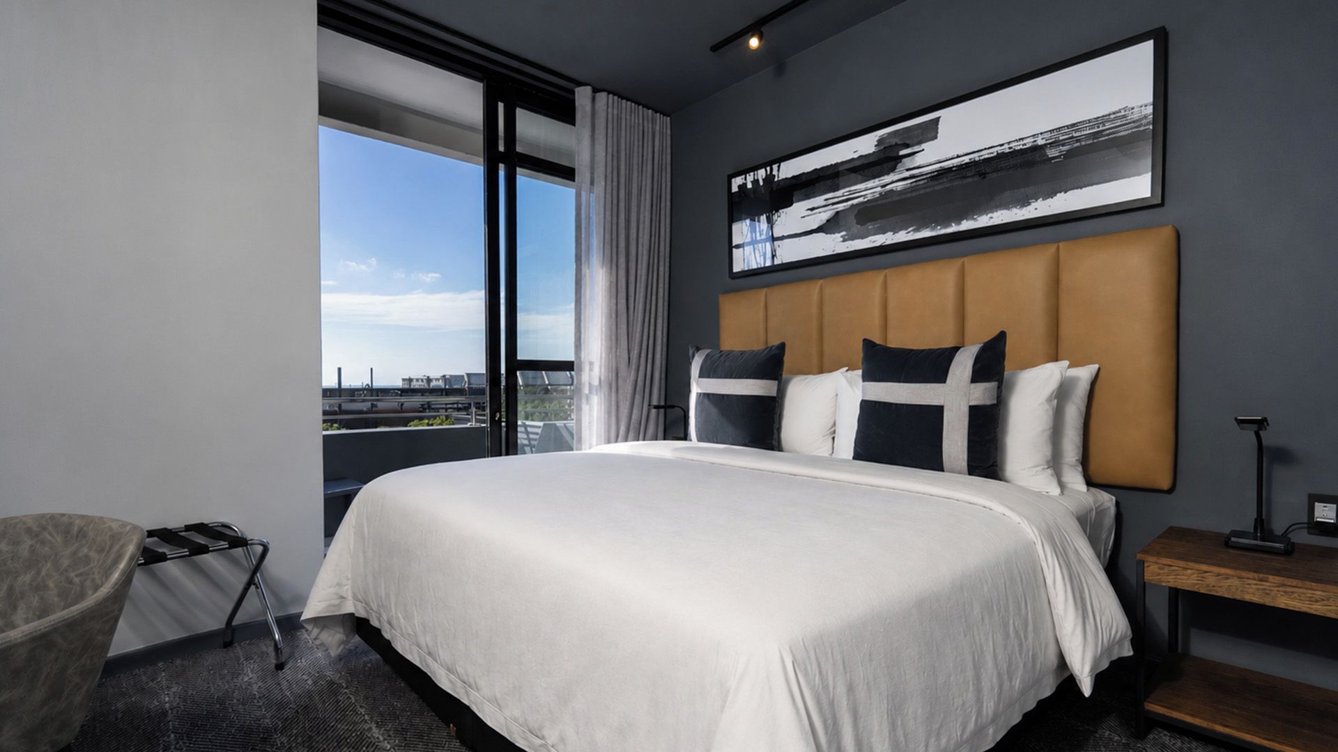 Ett hotellrum med en stor säng, utsikt över staden och en modern design.
