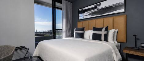 Une chambre d’hôtel avec un grand lit, une vue sur la ville et un design moderne.