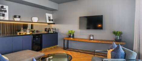Una sala de estar moderna con un sofá, una mesa de centro y un televisor montado en la pared.