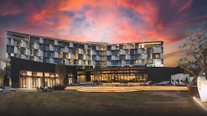 A modern hotel with a courtyard, multiple balconies, and a well-lit entrance. - The Capital Boardwalk (Gqeberha)