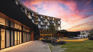 A modern building with a courtyard, outdoor seating, and a pool area. - The Capital Boardwalk (Gqeberha)