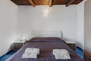 Ein Schlafzimmer mit Bett, Nachttischen und einem Kleiderschrank.