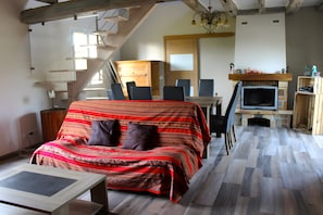 A room with a sofa, a TV, a fireplace, and a staircase. - Guest Room "La Pastuline" – Comfortable Stay Near Town Center (Montlouis-sur-Loire)