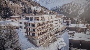 Un hôtel moderne, doté de plusieurs étages, avec une piste de ski en arrière-plan.
