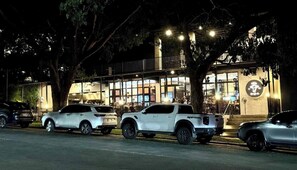 A row of parked SUVs in front of a building with large windows and a sign with a circular logo. - Calm and Clean Getaway + 400mbps+Netflix+Disney (Silang)
