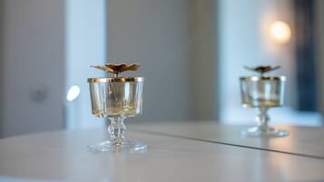 Two clear glass vases with gold accents on a reflective surface.