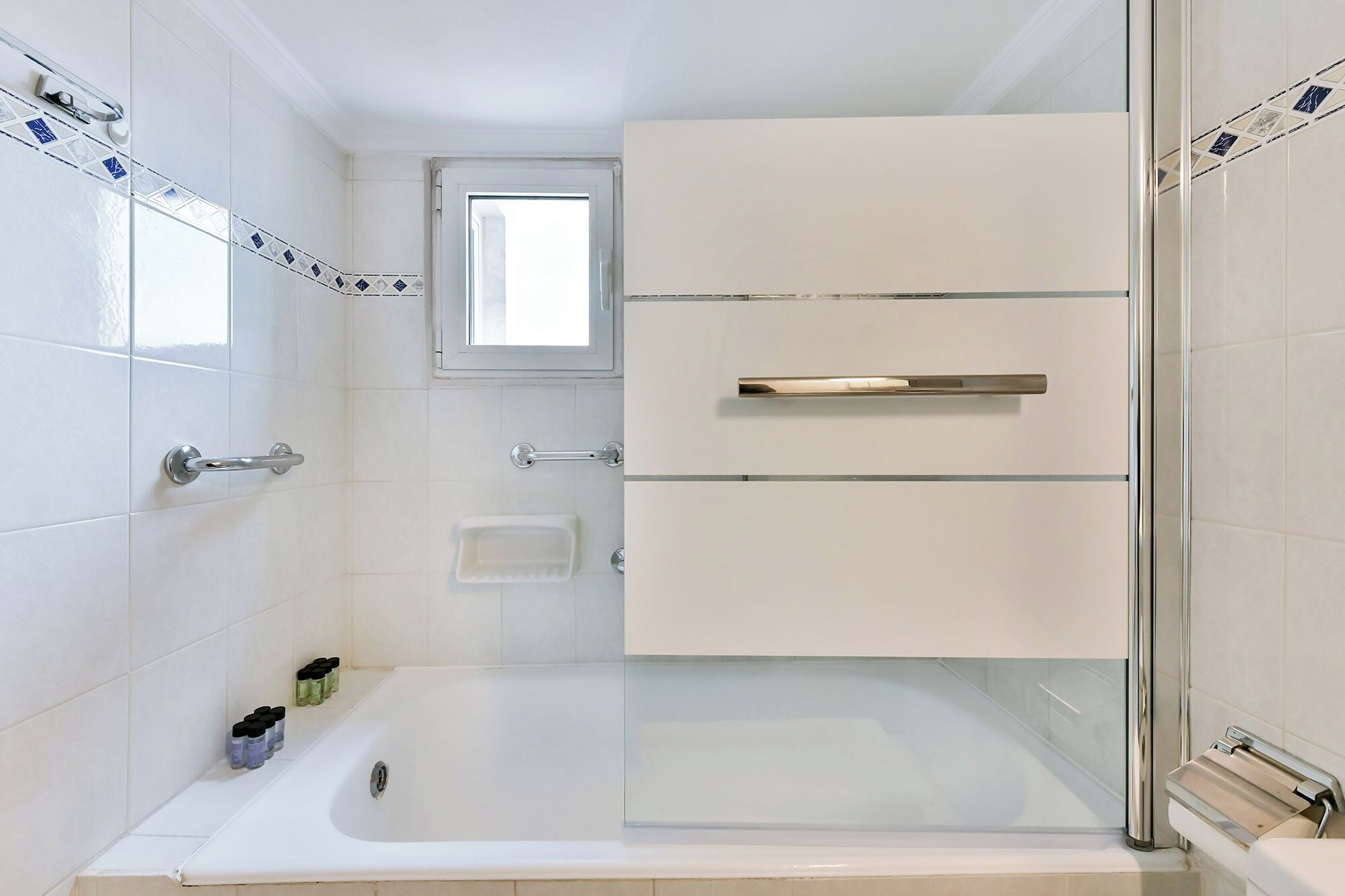 A modern bathroom with a glass-enclosed shower, a bathtub, and a vanity with a mirror.
