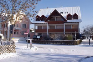 Un edificio de varios pisos con techo nevado y balcones.