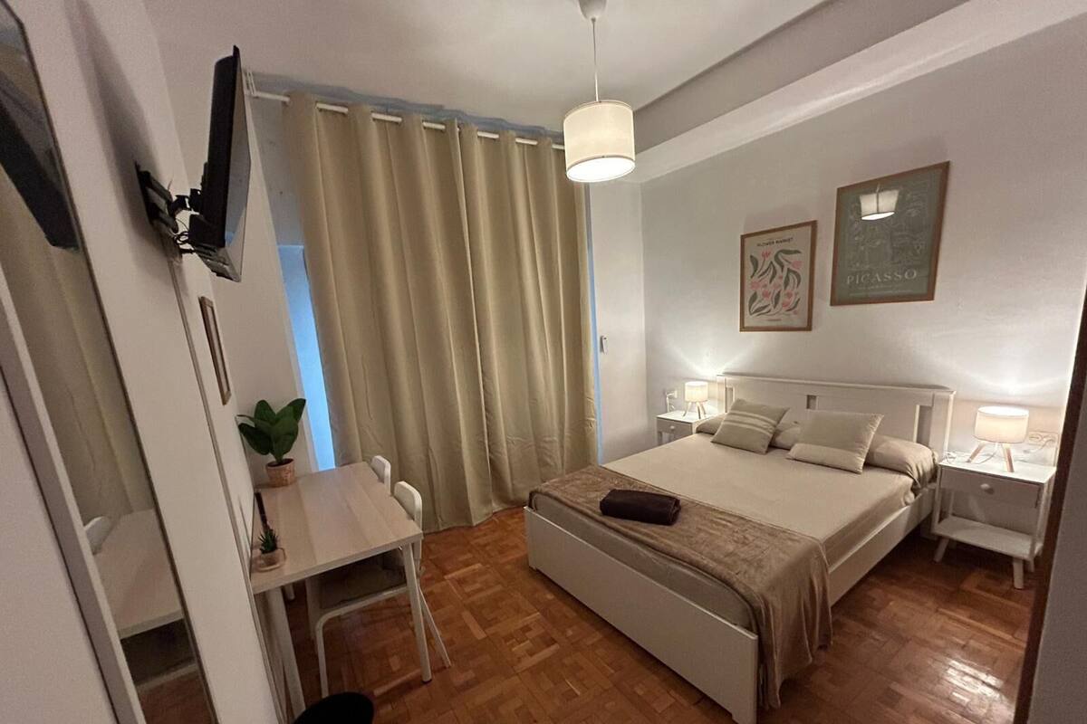 Ein Hotelzimmer mit Bett, Nachttischen, Schreibtisch und Stuhl.