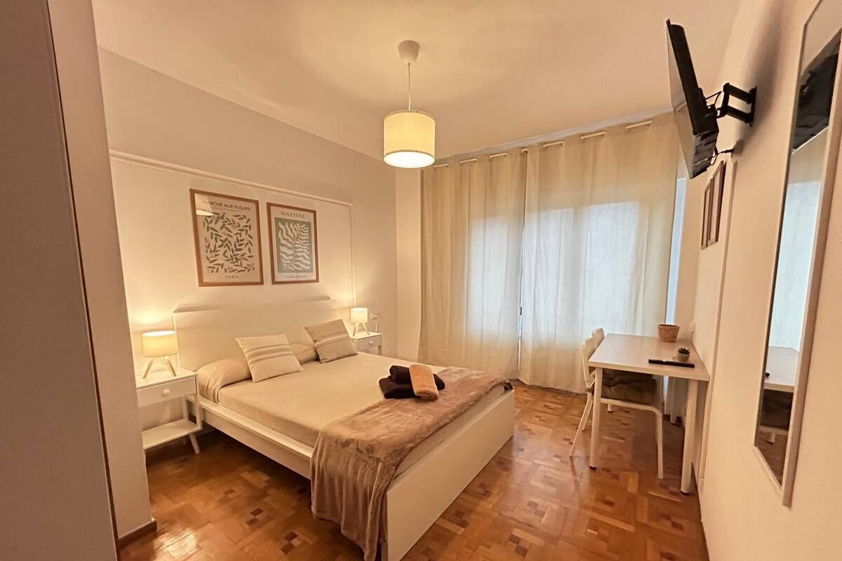 Ein Schlafzimmer mit einem Bett, Nachttischen, einem Schreibtisch und einem Stuhl.