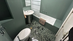 A bathroom with a toilet, sink, and bathtub. - Rooms Rey junto a Plaza España (Madrid)