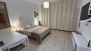 A modern bedroom with a bed, bedside table, lamp, and a TV mounted on the wall. - Rooms Rey junto a Plaza España (Madrid)