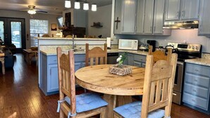 A kitchen with wooden chairs, a round table, and a built-in island. - Golf-Course View Retreat w/ Fireplace & Patio (Ruidoso)