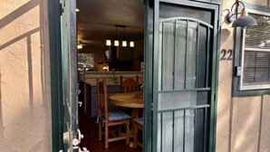 An open door to a room with a dining table and chairs, a kitchen area visible through the door, and a number '22' on the wall. - Golf-Course View Retreat w/ Fireplace & Patio (Ruidoso)