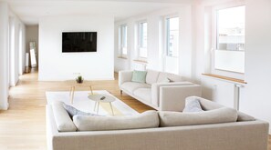 A modern living room with a sofa, coffee table, and a small plant.