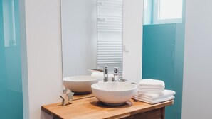 A modern bathroom with two sinks, a large mirror, and a wooden vanity. - Louis & Louise Apartments & Penthouses  (Bremen)